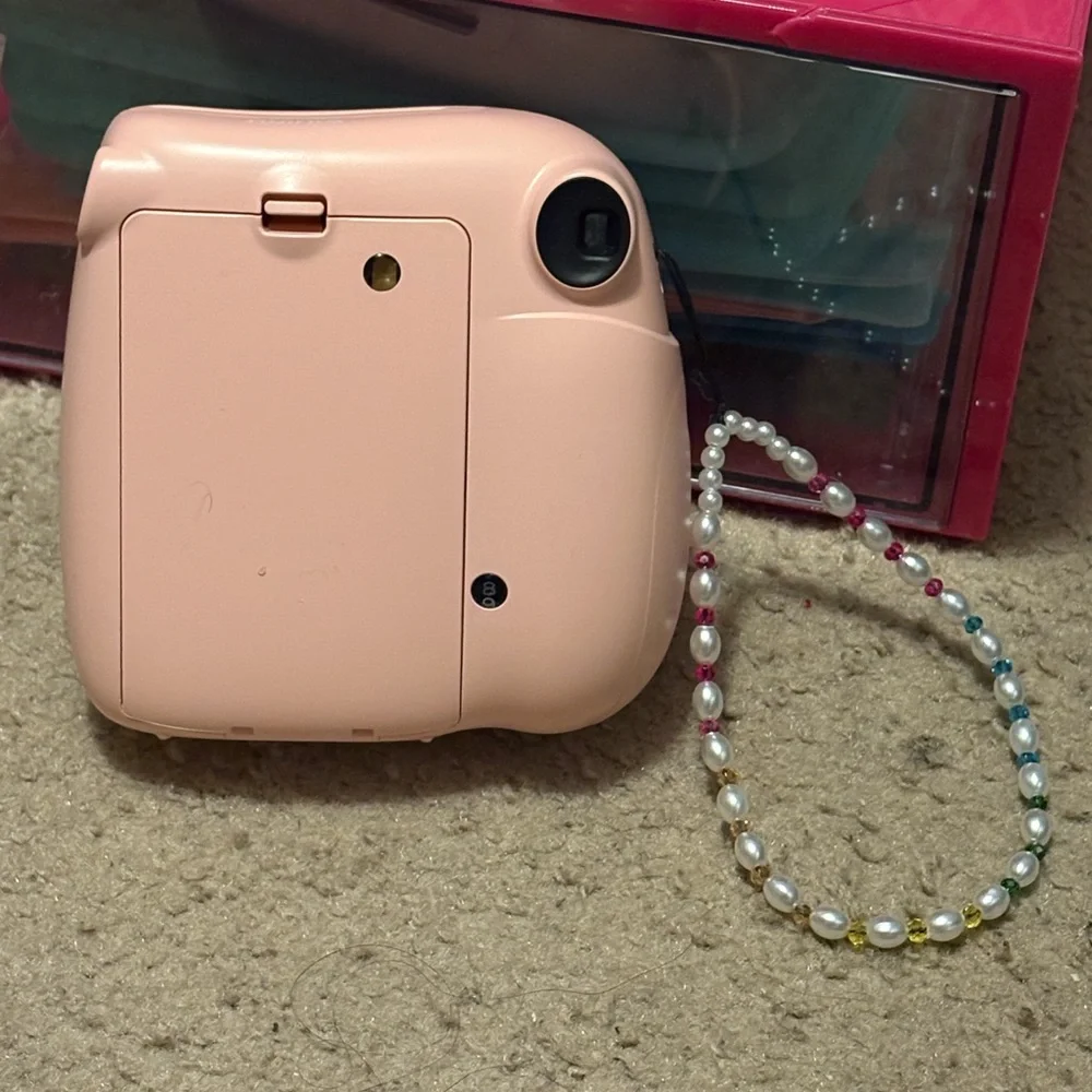 NWOT instax mini 7+ pink camera with a beaded lanyard (uses 4 AA batteries)